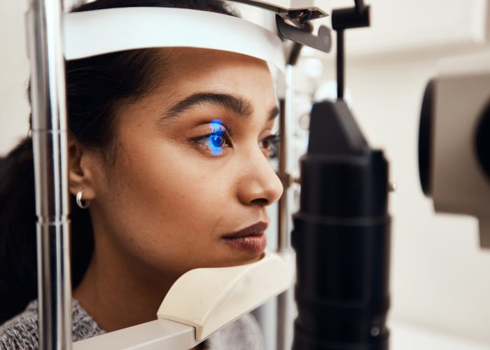 Shot of a young woman getting her eyes examined with a slit lamp.